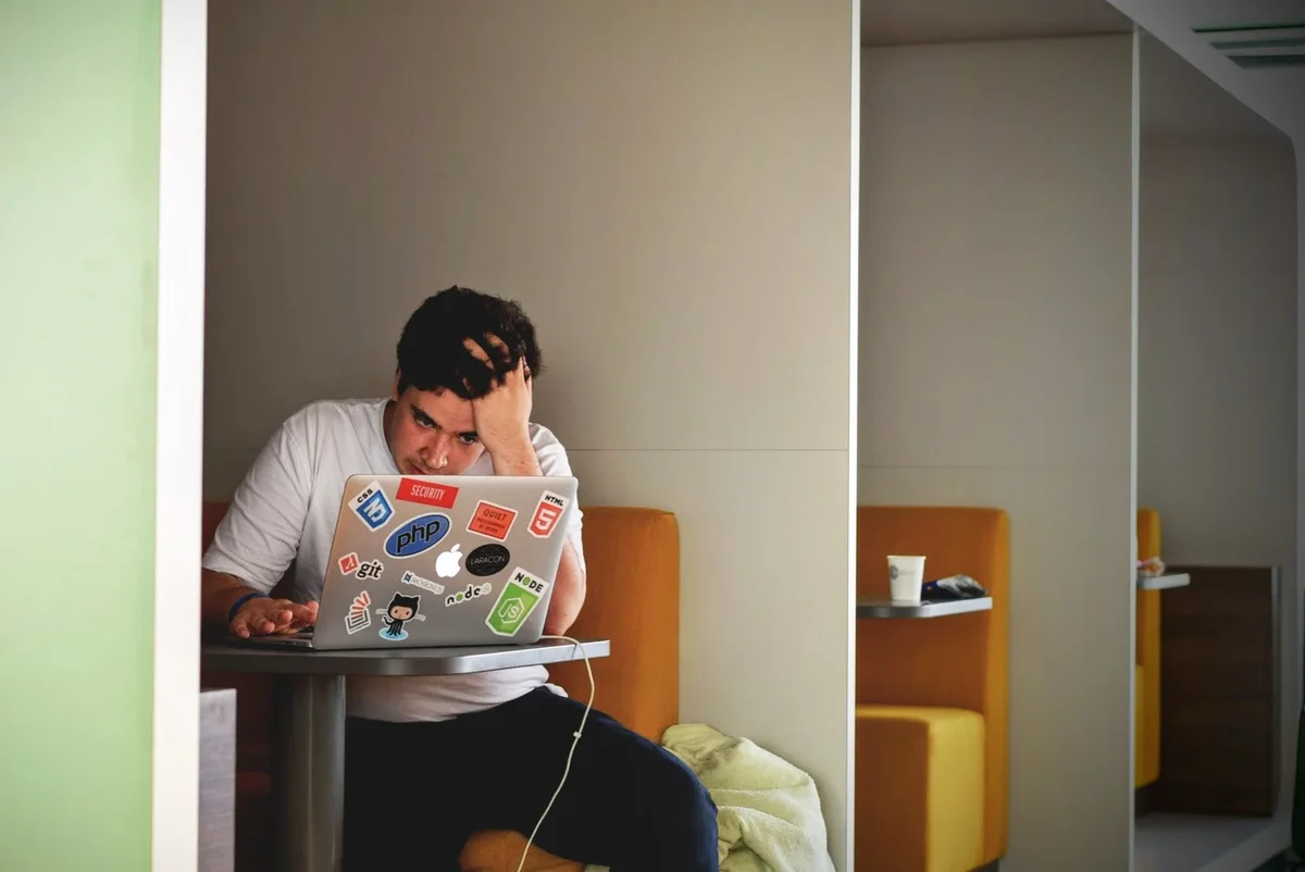 Personne au travail se tenant l'estomac, visiblement en proie au stress et à l'inconfort